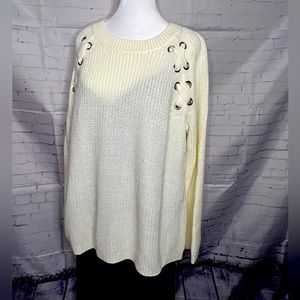 Loosefitting cableknit pull over sweater in an off-white color.